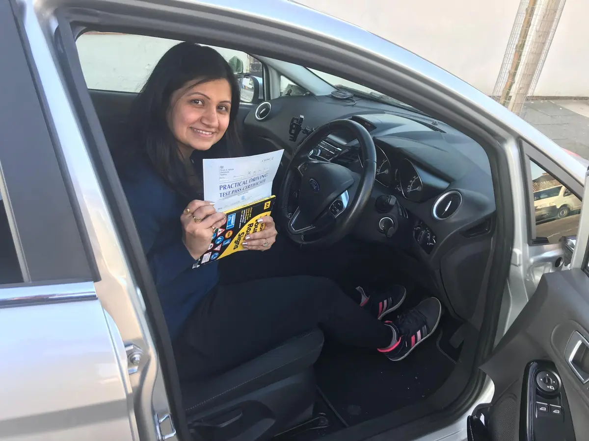 A successful ACDAL learner holding a practical driving test pass certificate